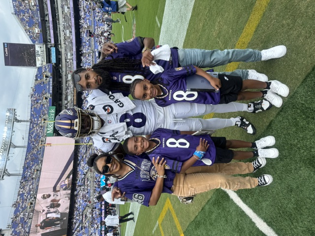 Lockie and his family with Lamar Jackson on the field